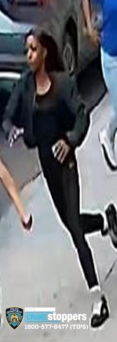 Individual #2 running past the scene of the car robbery. She was last seen wearing dark-colored clothing. 