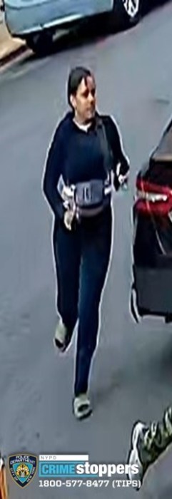 Individual #4 running past the scene of the car robbery. She was last seen wearing dark-colored clothing.