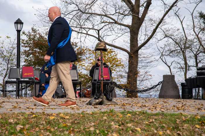 One of the parade's grand marshals, U.S. Marine Corps Lance Corporal Michael McNerney, marches away after hanging dog tags over a helmet that is perched atop a rifle, symbolizing veterans from the Bronx that have died.