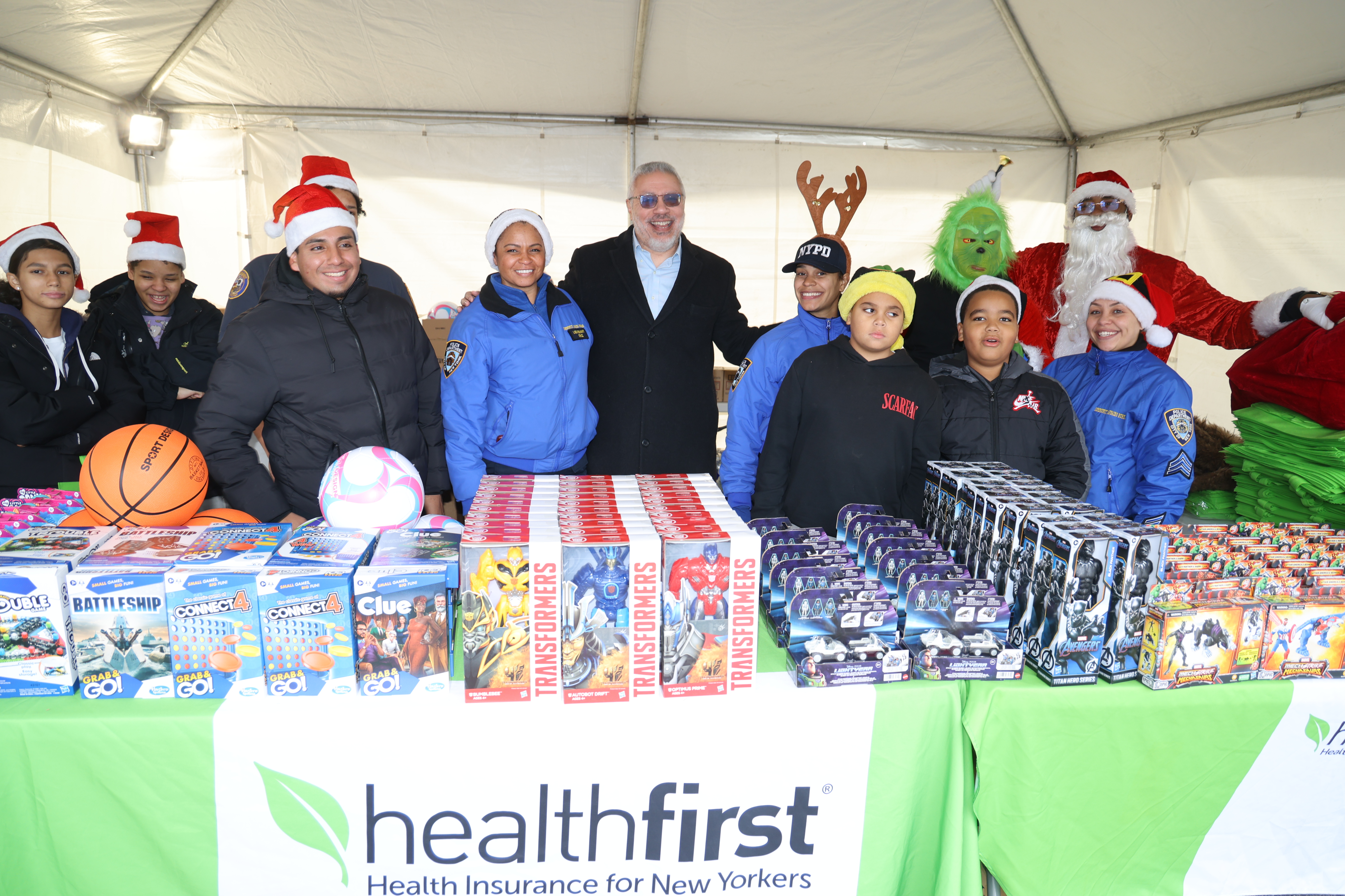 Miguel Centeno (center right), Healthfirst’s Vice President of Community Engagement, and NYPD Lieutenant Carolyn Cruz (center left) gather with volunteers and other members of the NYPD Community Affairs Bureau for a holiday toy giveaway in the Bronx on Saturday, Dec. 13th.