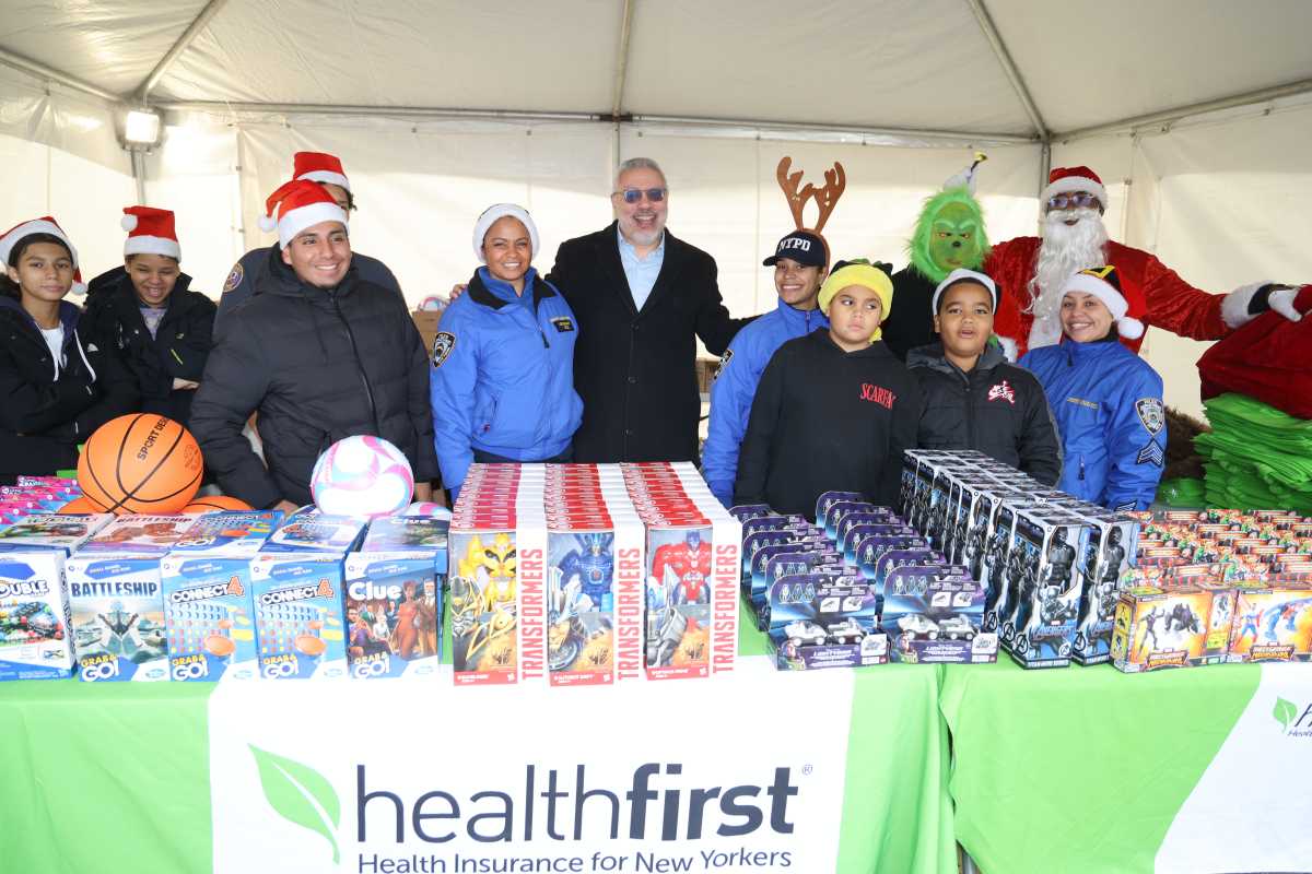 Miguel Centeno (center right), Healthfirst’s Vice President of Community Engagement, and NYPD Lieutenant Carolyn Cruz (center left) gather with volunteers and other members of the NYPD Community Affairs Bureau for a holiday toy giveaway in the Bronx on Saturday, Dec. 13th.