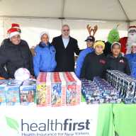Miguel Centeno (center right), Healthfirst’s Vice President of Community Engagement, and NYPD Lieutenant Carolyn Cruz (center left) gather with volunteers and other members of the NYPD Community Affairs Bureau for a holiday toy giveaway in the Bronx on Saturday, Dec. 13th.