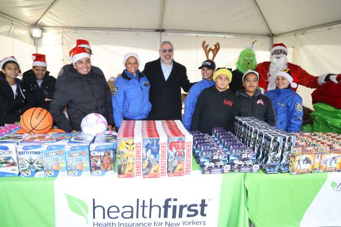Miguel Centeno (center right), Healthfirst’s Vice President of Community Engagement, and NYPD Lieutenant Carolyn Cruz (center left) gather with volunteers and other members of the NYPD Community Affairs Bureau for a holiday toy giveaway in the Bronx on Saturday, Dec. 13th.