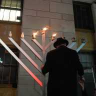 A Rabbi lights a menorah in front of Chabad of South Bronx during Hanukkah.