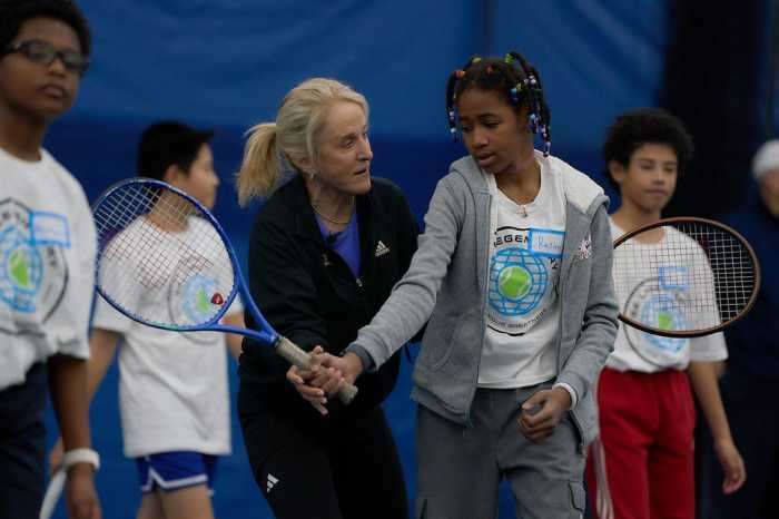 Professional Tracy Austin guides a young tennis player through a swing on Sunday. The tennis legend spent a couple hours in the Bronx hosting a workshop and helping young players with their skills.
