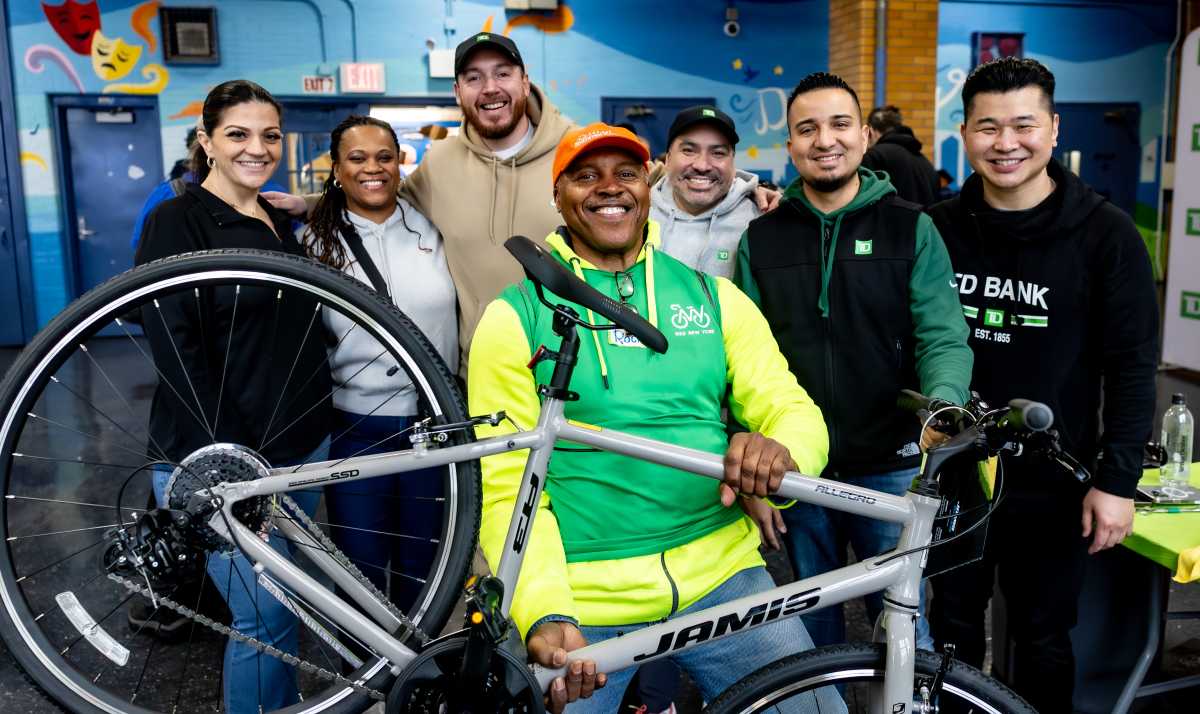 TD Bank volunteers and Bike New York instructors pose in front of a newly-built bike.