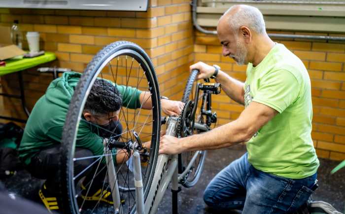 Alan Nossen works with TD bank volunteers to build a bike.