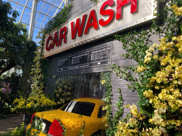 A makeshift car wash with a yellow cab made of flowers at the New York Botanical Garden.
