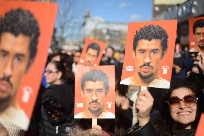 Spectators line up behind a barricade to catch a glimpse of the Bad Bunny lookalikes.