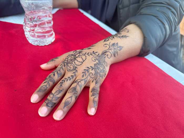 A girl gets her henna design done on Chaand Raat for Eid.