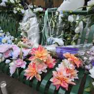 Flowers, garlands, and candles lay on the bench where 78-year old Edgar Spence was killed by a stray bullet on Thursday.