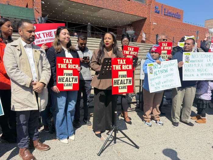 Assemblymember Amanda Septimo speaks out against the Essential Plan cuts at the Tax the Rich rally, alongside State Sens. Jose Serrano and Kristen Gonzalez.