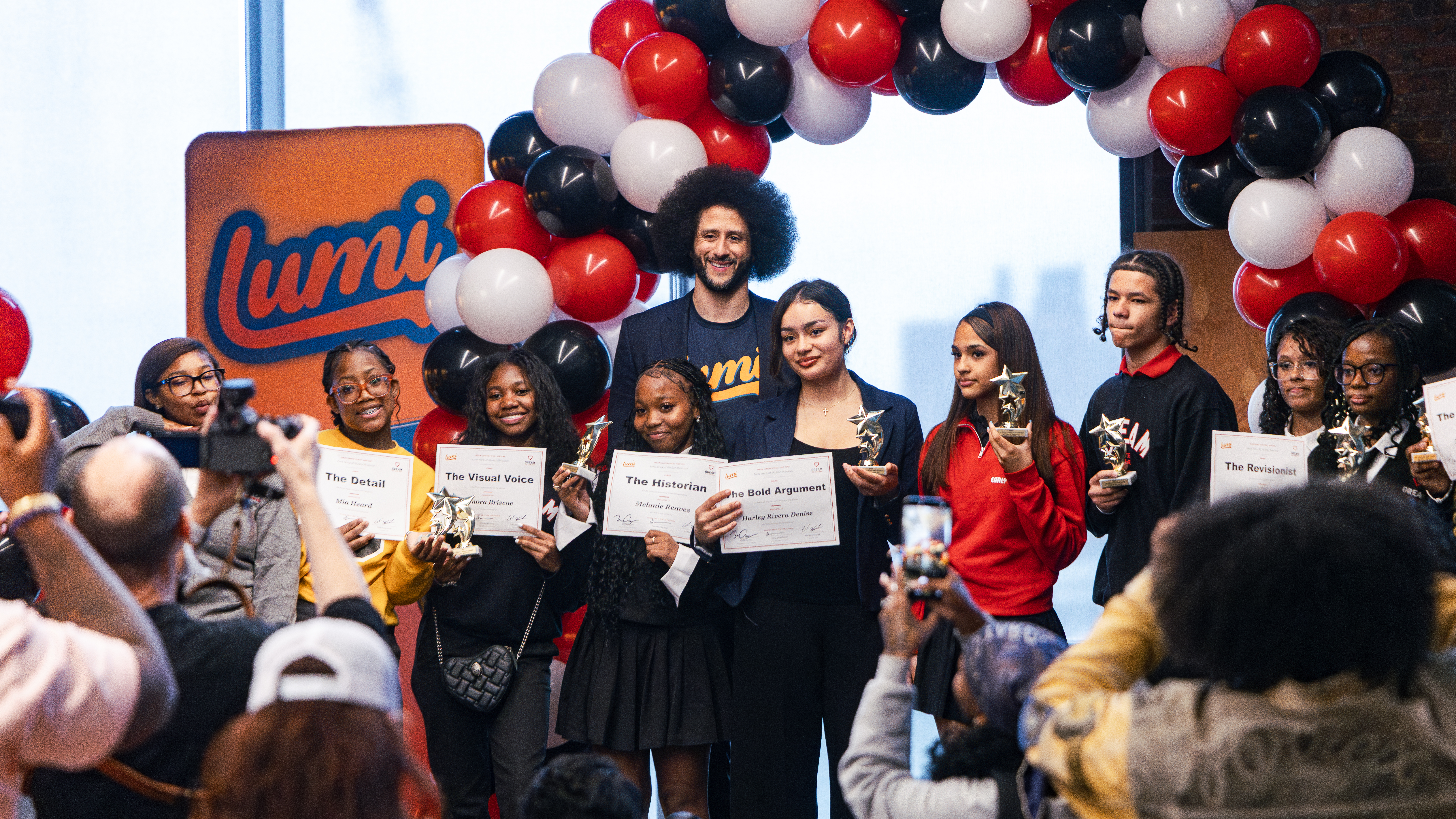 Colin Kaepernick, founder of LUMI AI, poses with ten ninth graders who created graphic novels using the app at DREAM Charter School in Mott Haven.