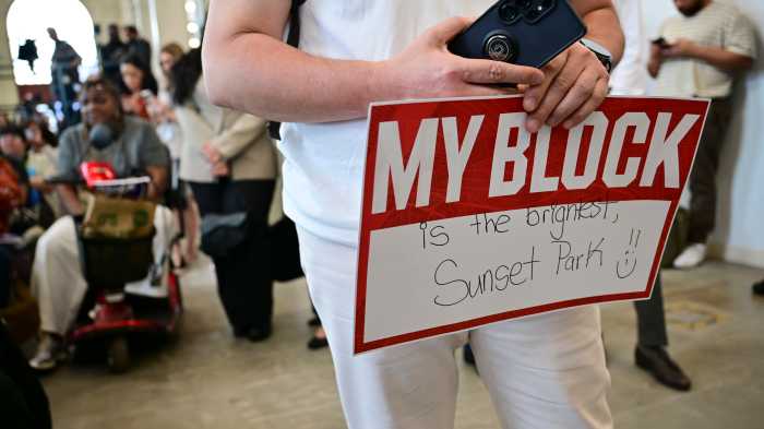 Attendees cheer and hold up signs in support of the Mayor's "Block by Block" plan.