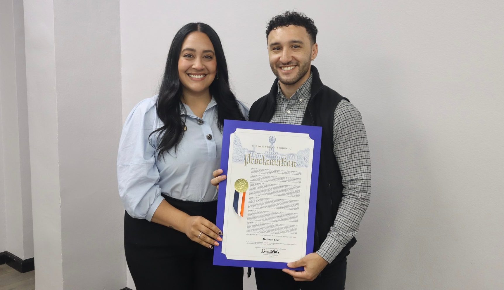 Bronx Community Board 10 District Manager Matt Cruz receives proclamations from Council Member Amanda Farías