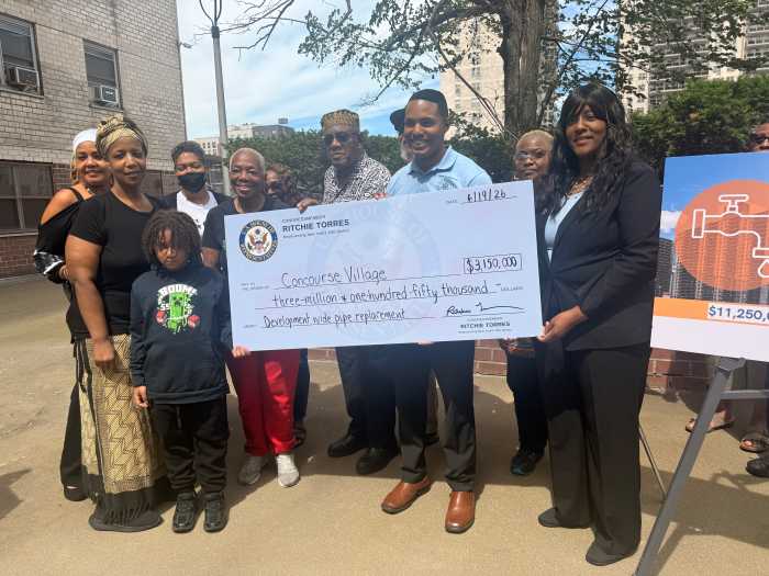 Rep. Ritchie Torres presents residents of Concourse Village with a ceremonial check to be put towards pipe replacement.