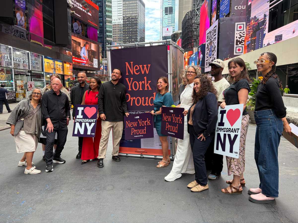 Photographer Oscar B. Castillo, Assembly member Amanda Septimo, State Senator Jessica González-Rojas, and members of New York Immigration Coalition pose at the launch of the third annual New York Proud art installation in Time Square.