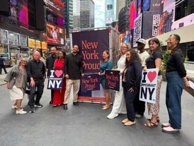 Photographer Oscar B. Castillo, Assembly member Amanda Septimo, State Senator Jessica González-Rojas, and members of New York Immigration Coalition pose at the launch of the third annual New York Proud art installation in Time Square.